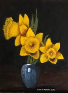 Three daffodils in blue glass